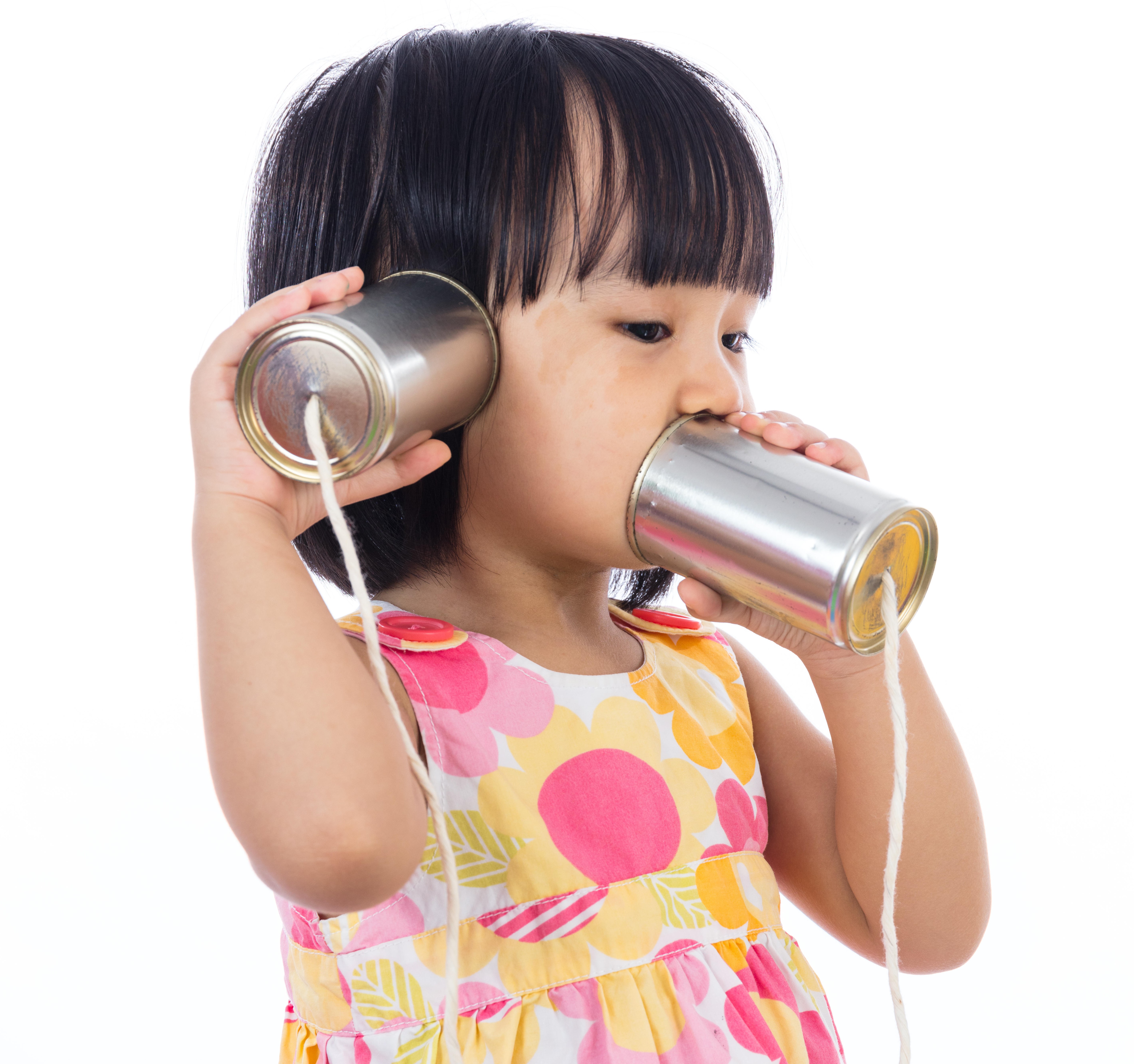 a child listening to its own voice through a cup and string phone