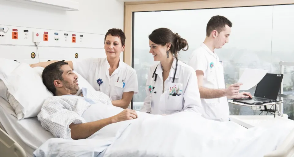 patient et soignants dans une chambre