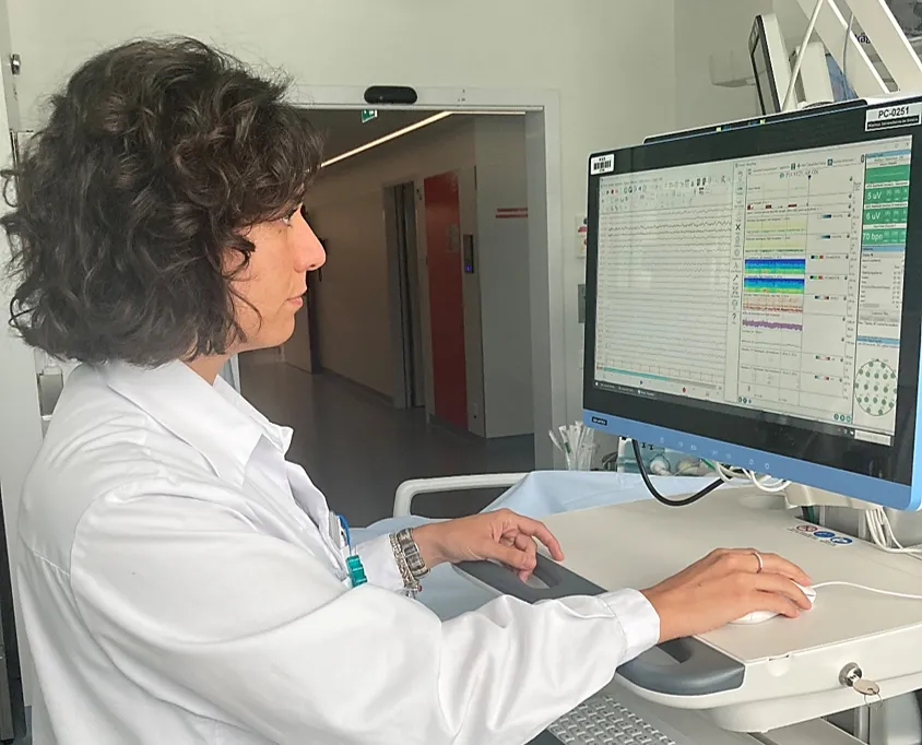 La Dre Pia De Stephano devant une machine d'EEG aux soins intensifs