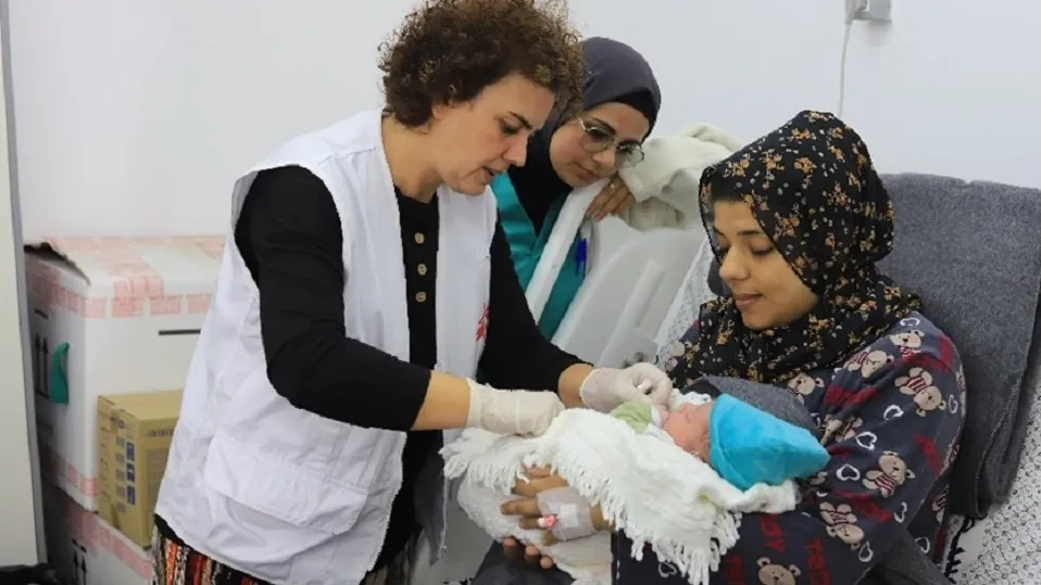 Le personnel médical de MSF discute avec un patient et examine un nouveau-né à l'hôpital Emirati de Rafah, dans le sud de Gaza.