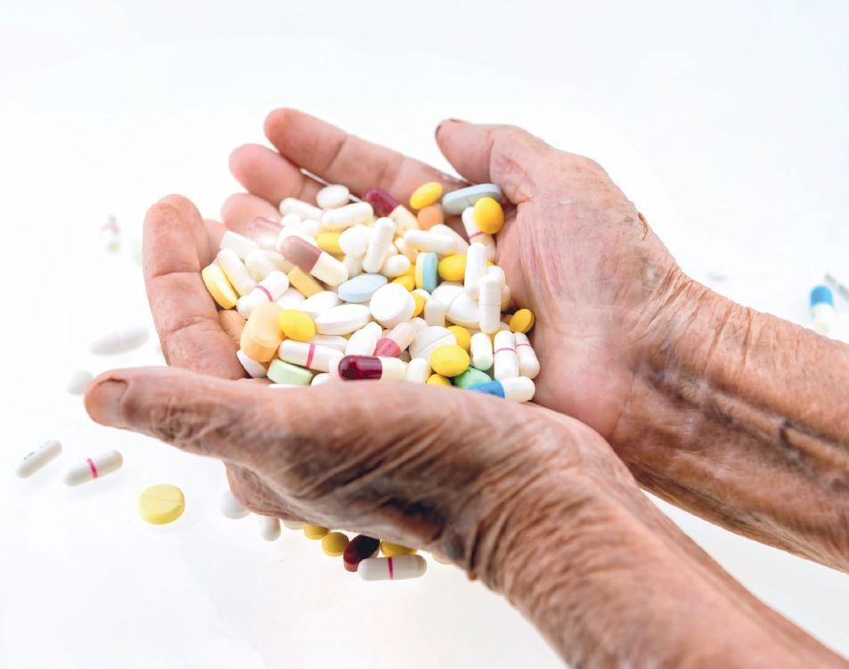 Mains avec plusieurs pilules de différentes couleurs