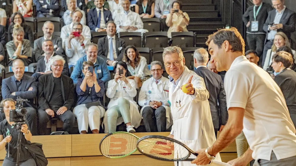 Le Pr Alain Gervaix échange des balles avec Roger Federer lors de l'inauguration de la MEA