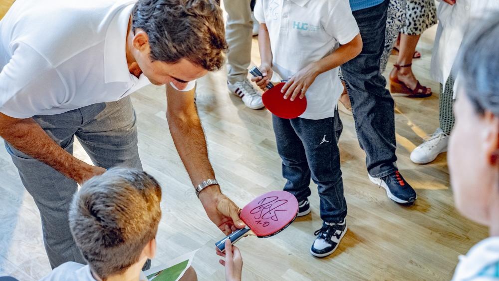 Roger Federer signe les raquettes des enfants lors de l'inauguration de la MEA