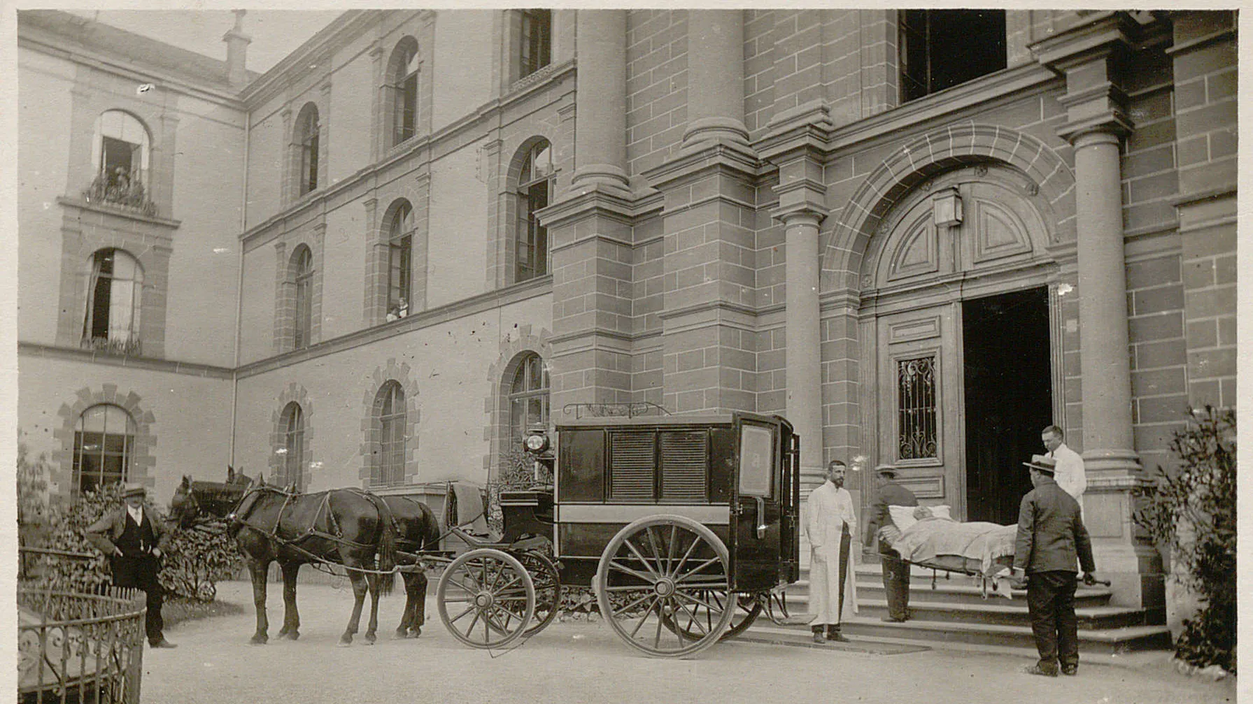 Entrée de l'Hôpital cantonal. Patient amené par chariot.