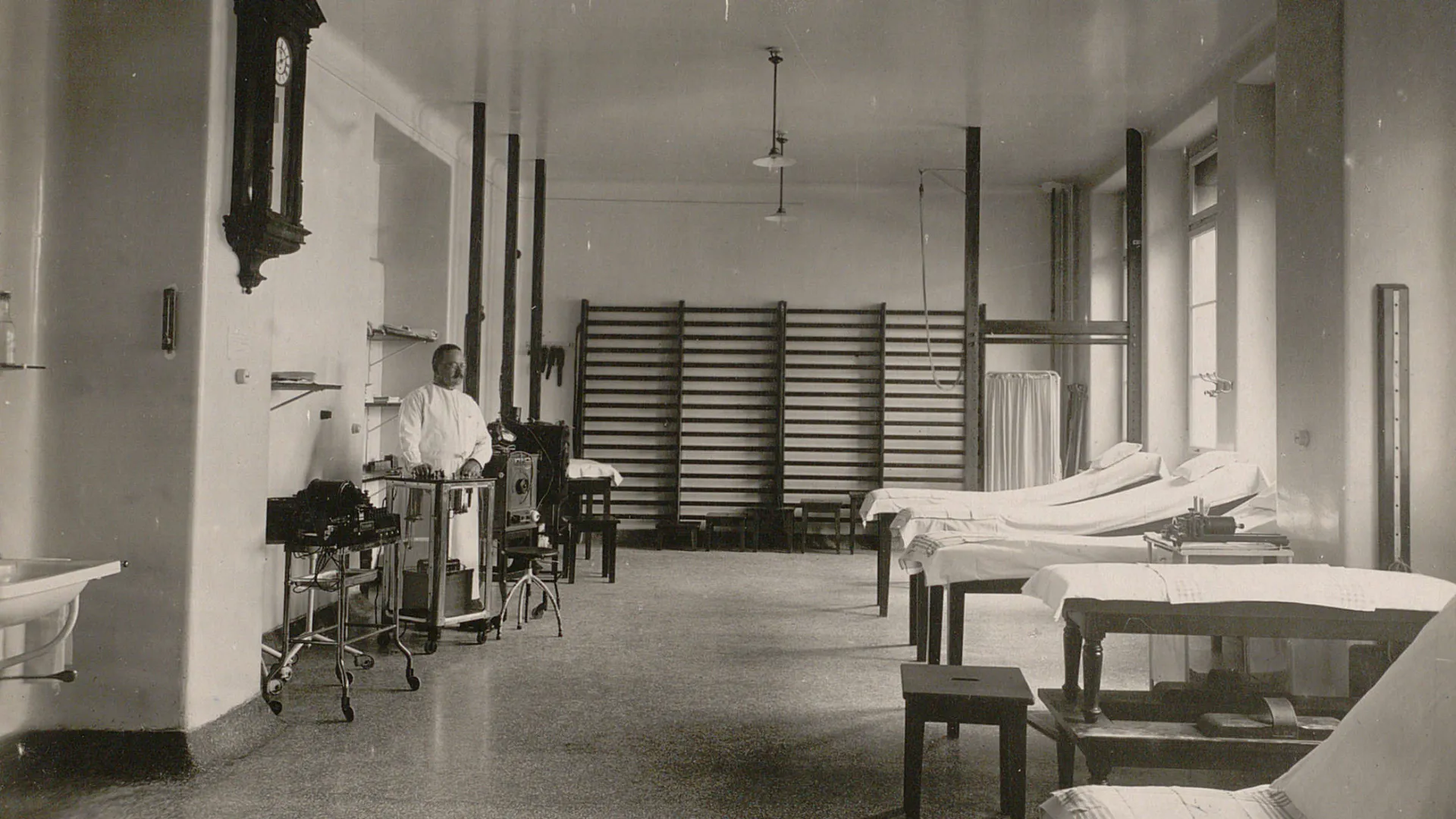 Salle équipée de tables de traitement, d'espaliers, de poutres.
