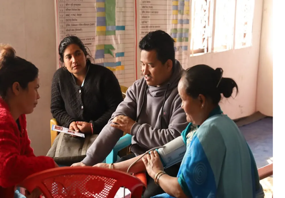 Atelier de formation des agentes de santé communautaires au poste de santé de Phawakhola, dans la municipalité de Phungling. Les agentes de santé communautaires, reconnaissables à leur tenue de travail bleue, apprennent à dépister la population à haut risque de MNT, à mener des actions de prévention au sein de la communauté, et à faire un suivi des patients ayant une MNT. Source : Instagram @khdcnepal.