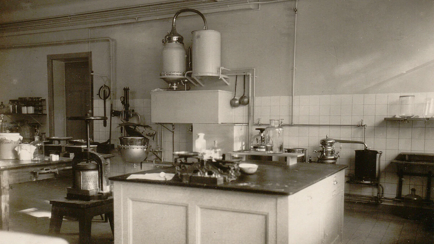 Plan de travail avec une petite balance, un pressoir, une chaudière.