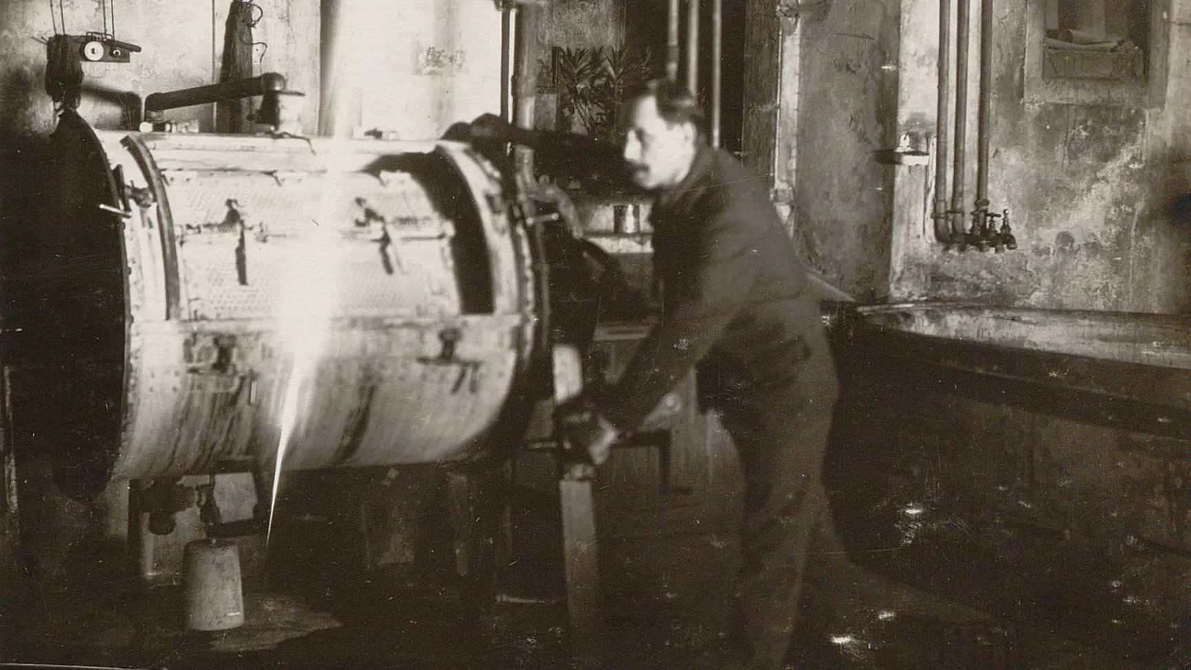 Un homme s'active sur le tambour d'une machine à laver.