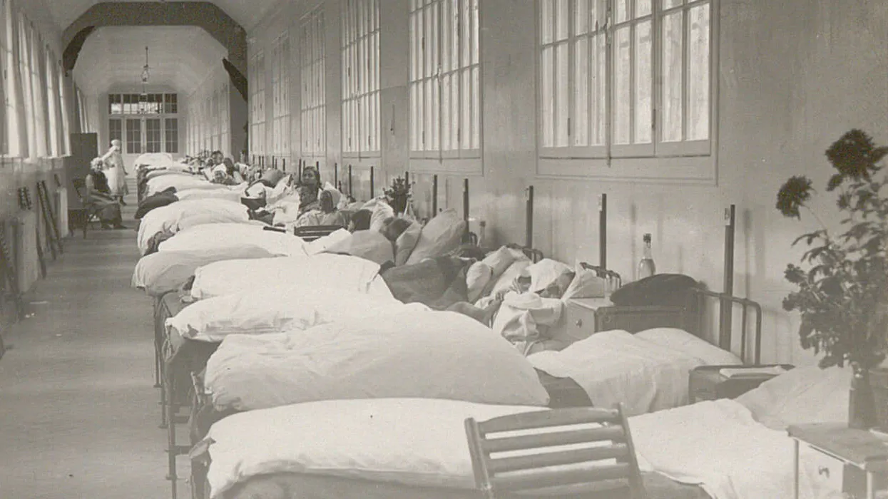 De nombreux lits sont alignés dans la grande passerelle, des femmes y sont assises ou alitées.