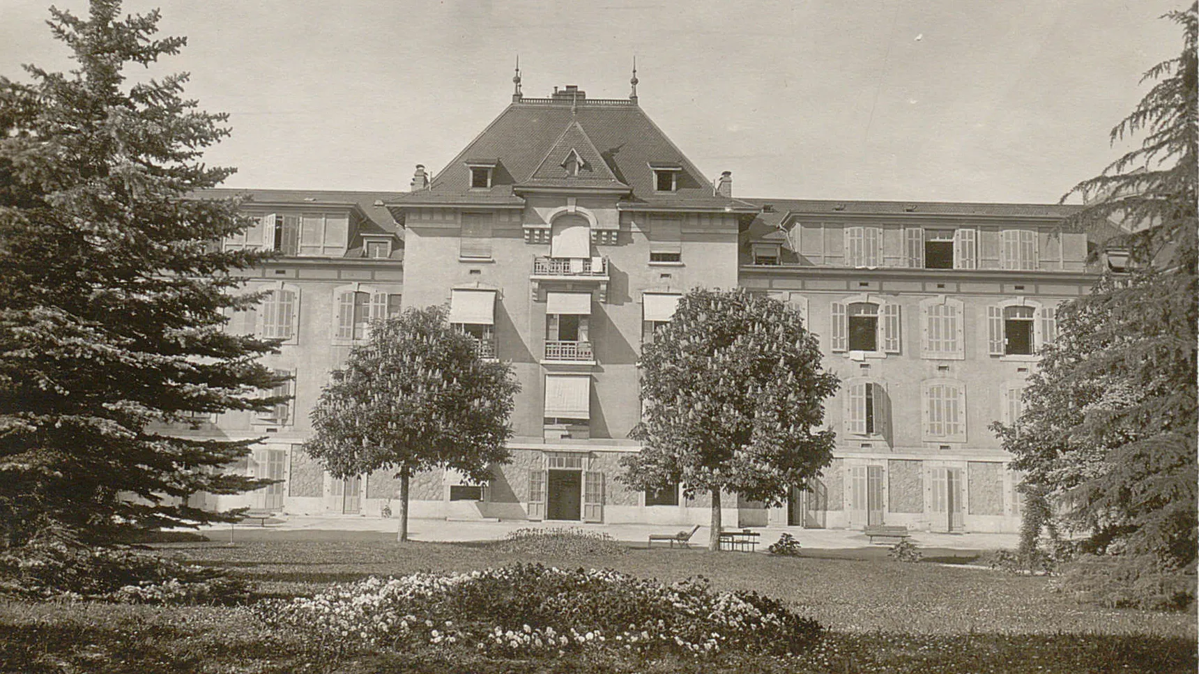 Vue sur la face arrière de la Maternité depuis le jardin, les marronniers sont en fleurs.