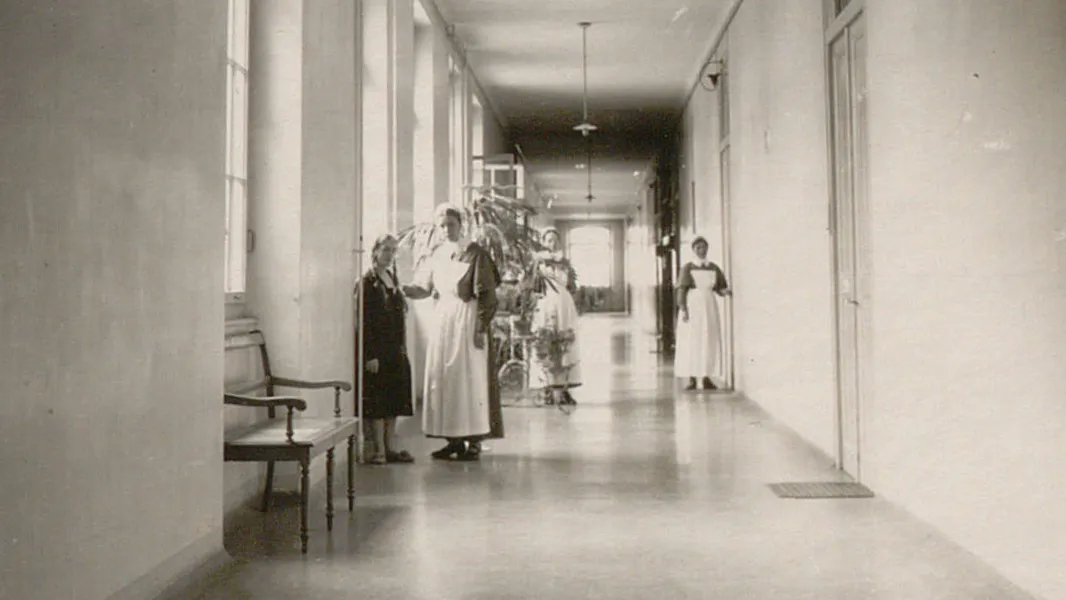 Couloir avec une patiente et plusieurs diaconesses