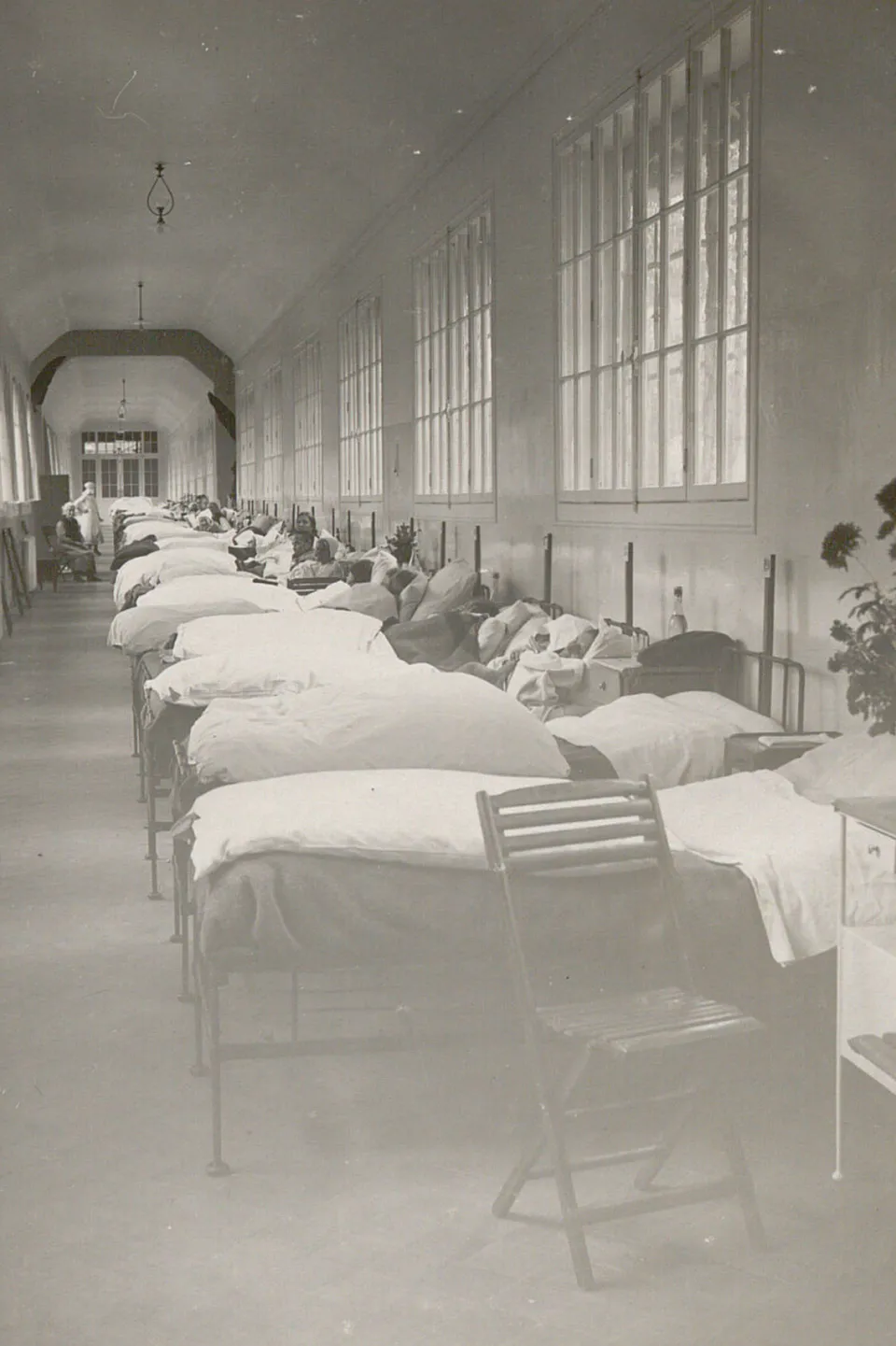 De nombreux lits sont alignés dans la grande passerelle, des femmes y sont assises ou alitées.