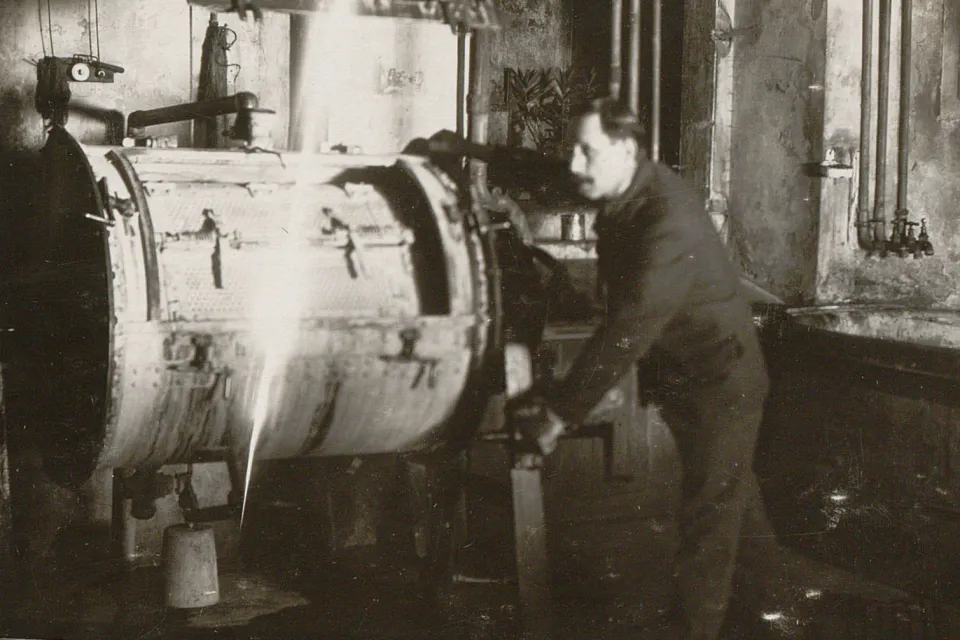 Un homme s'active sur le tambour d'une machine à laver.