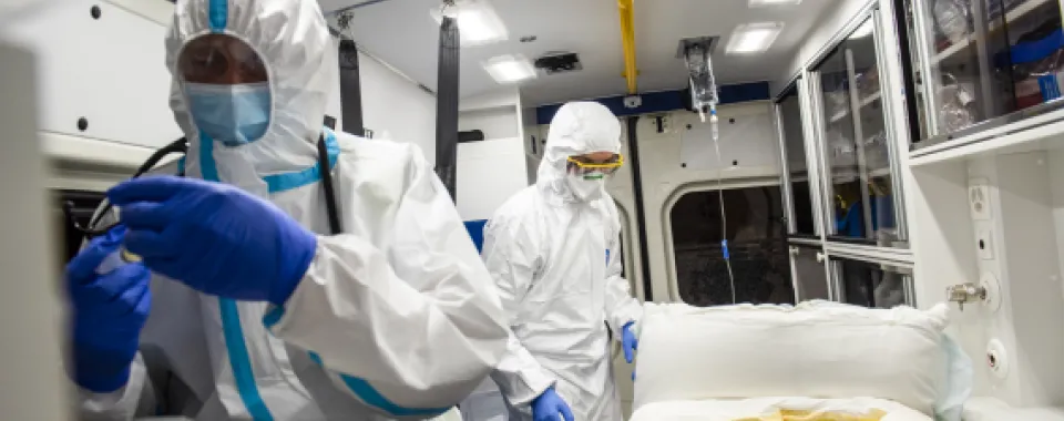 Soignants en tenue de protection dans une ambulance